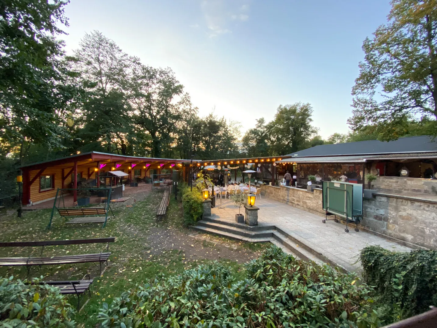 Außengelände der Saloppe mit Wiese, Bänken und Terrasse