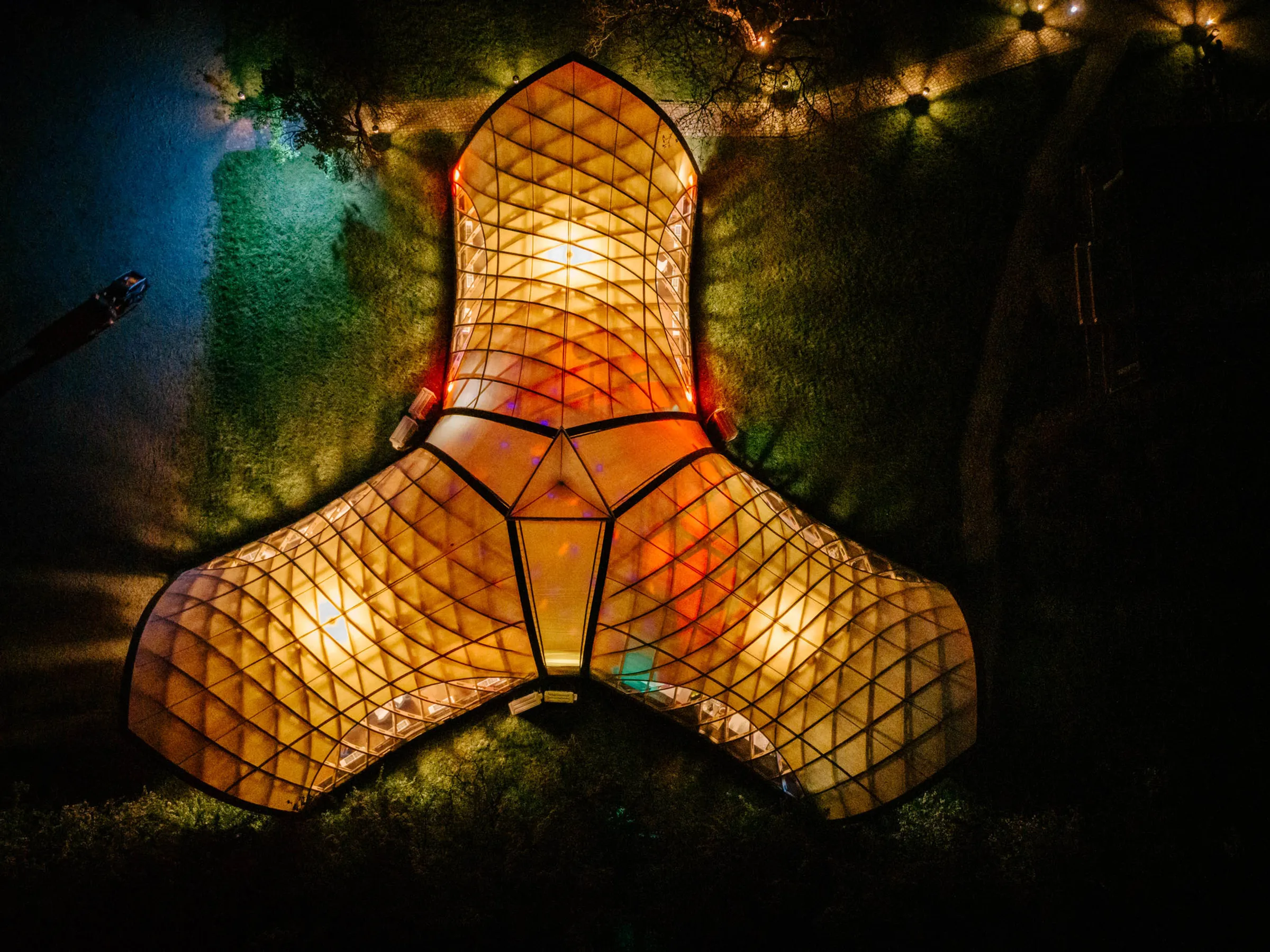 Beleuchteter Eventpavillon bei Nacht aus der Vogelperspektive