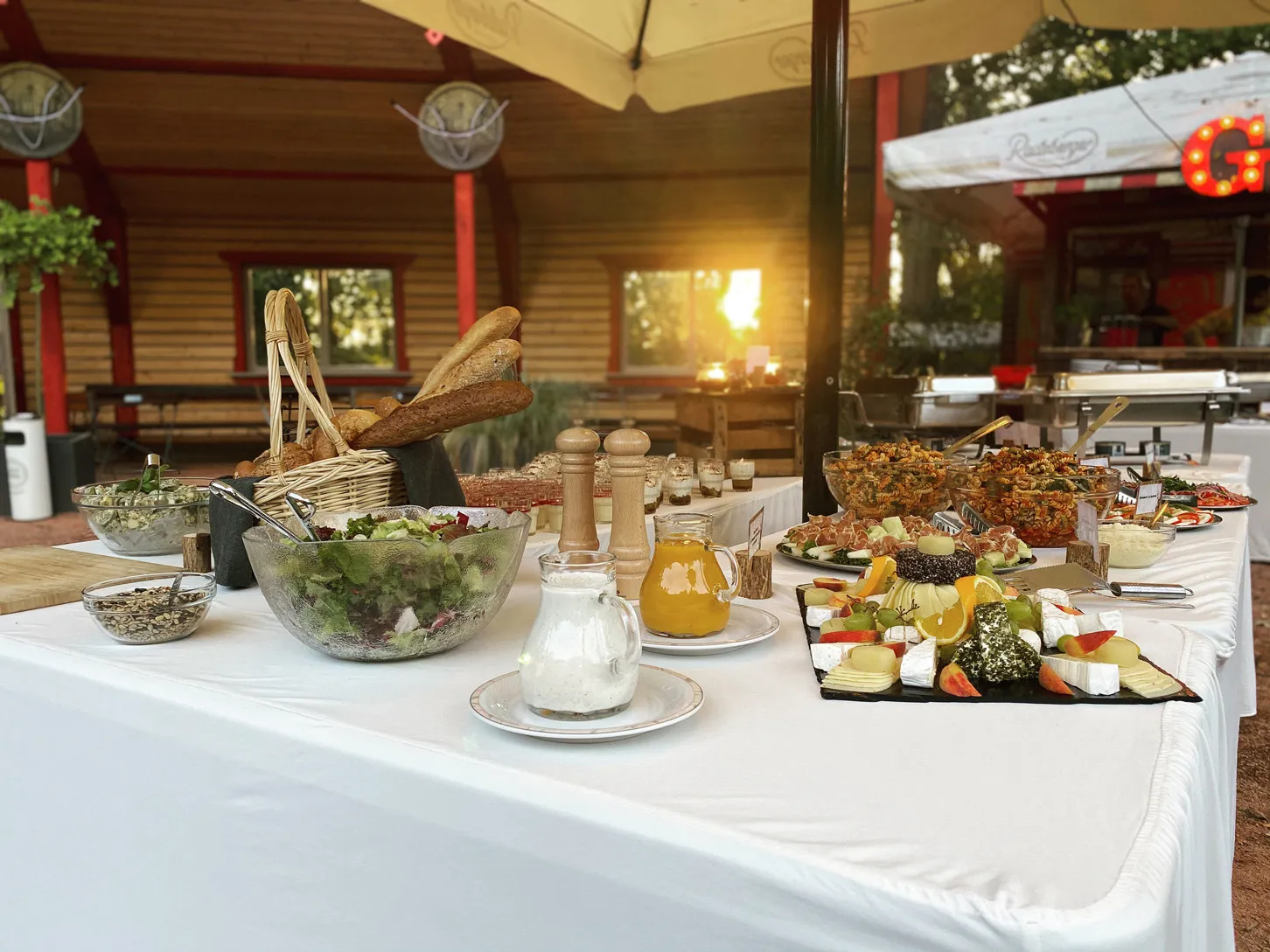 Buffet mit Salaten, Brotkorb und Käseplatte im Freien