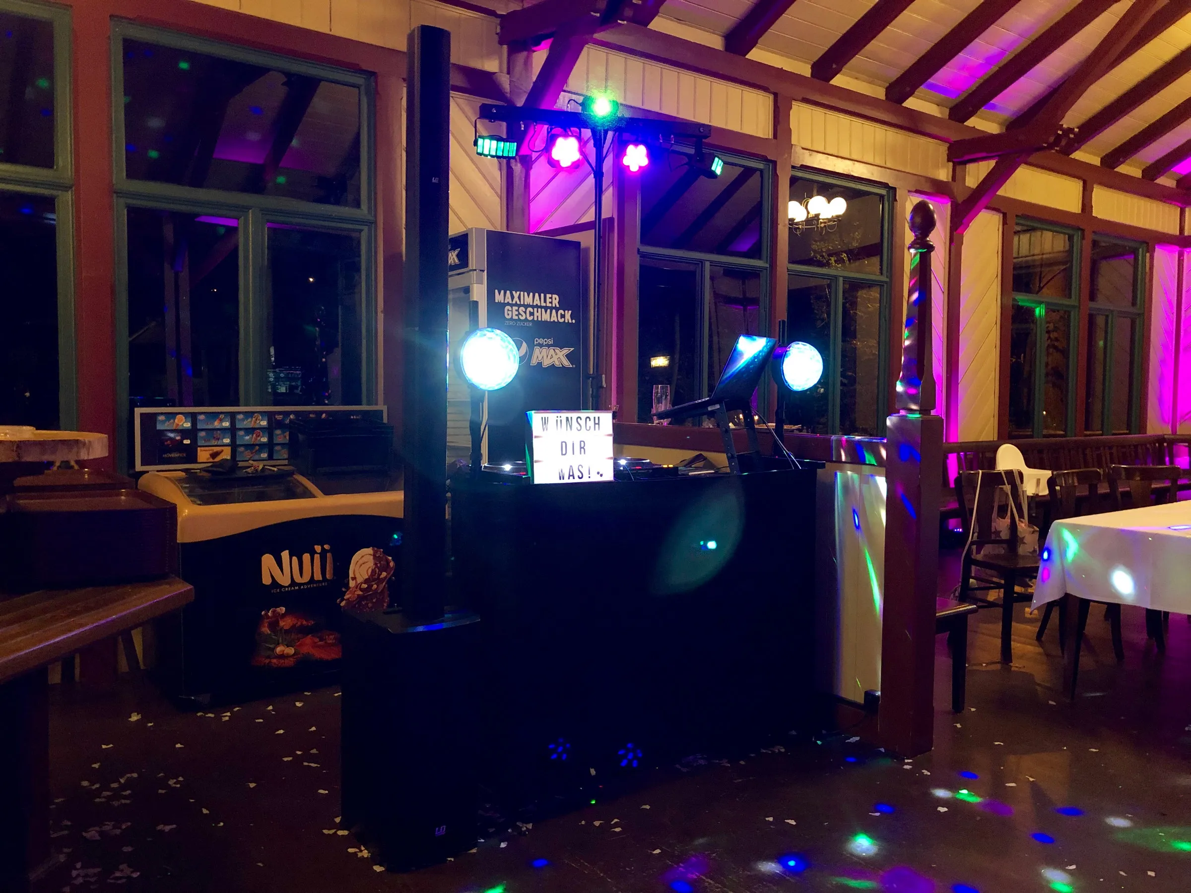 DJ-Pult mit farbiger Beleuchtung im Gartenhaus am Abend
