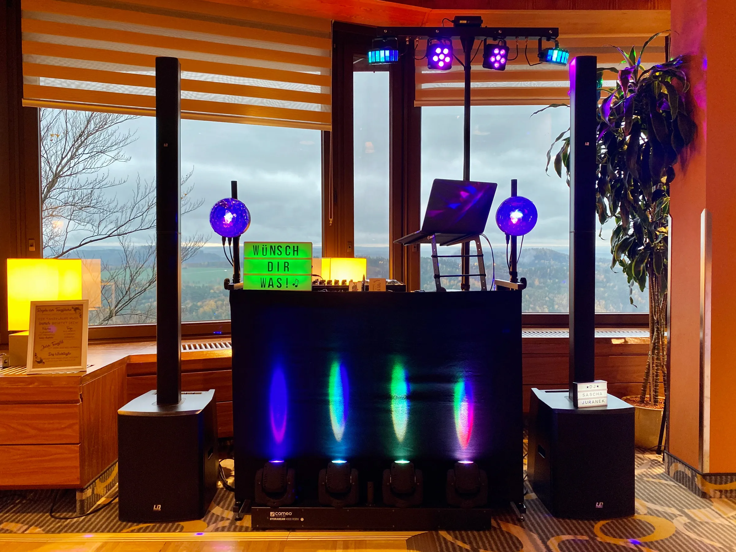 DJ-Pult mit Lichttechnik vor großen Panoramafenstern