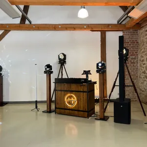 DJ-Technik in einer leeren Location mit Backsteinwand und Dachbalken