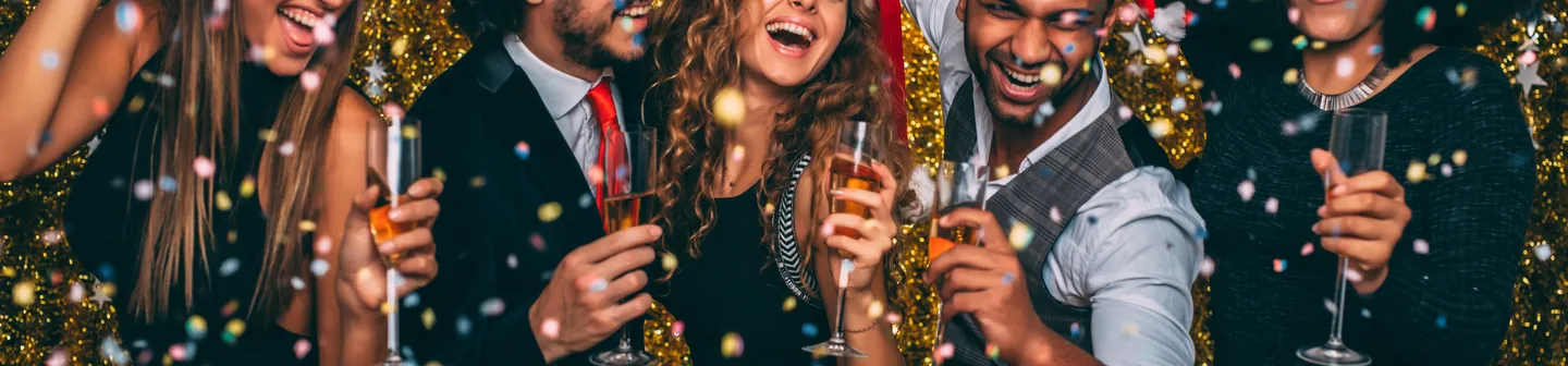Feiernde Gäste mit Weihnachtsmützen auf einer Firmenweihnachtsfeier