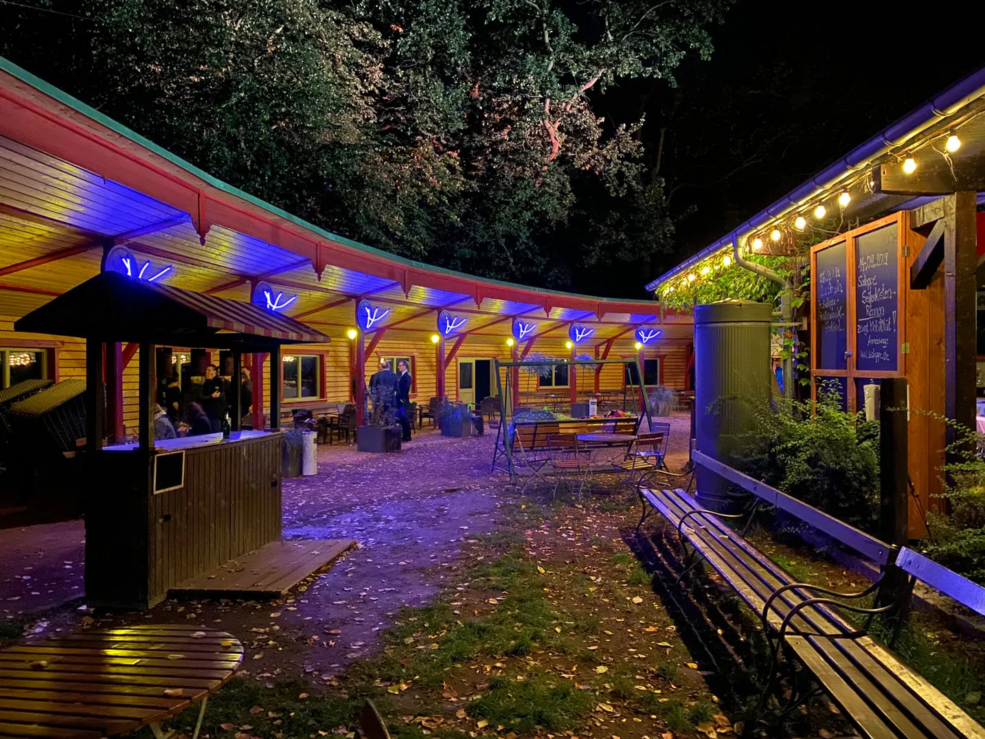 Geschwungener Holzbau der Saloppe mit blauer Beleuchtung nachts