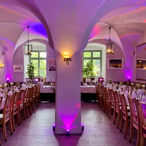Gewölbekeller mit gedeckten Tafeln und violettem Ambientelicht