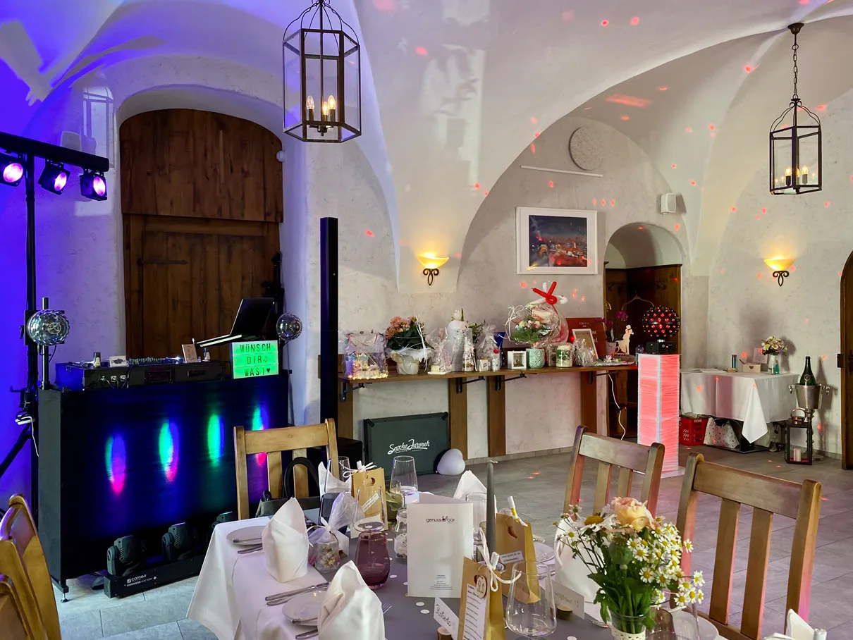 DJ-Pult mit Wunschschild und Geschenketisch im Gewölberaum der Genussbar