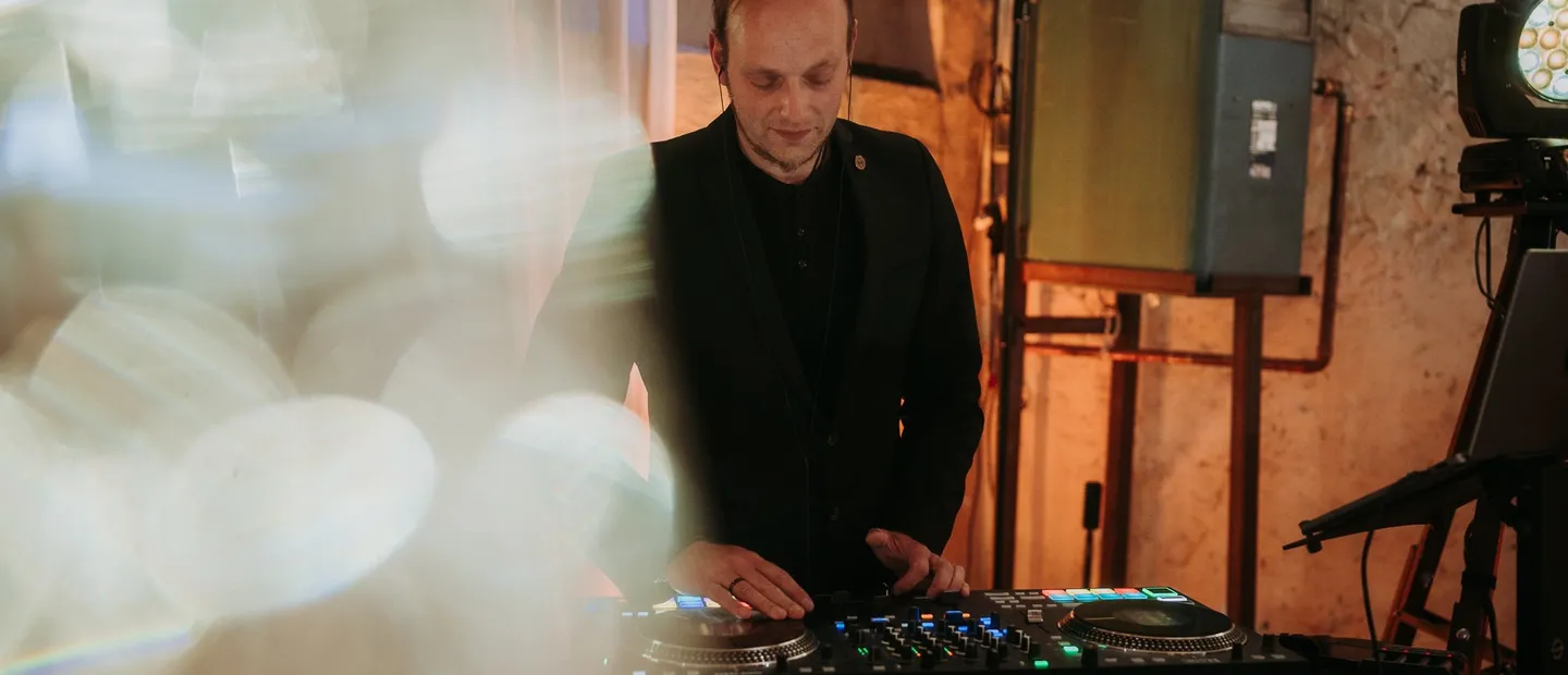 Hochzeits-DJ Sascha Juranek am Pult beim Mixen von Liedern