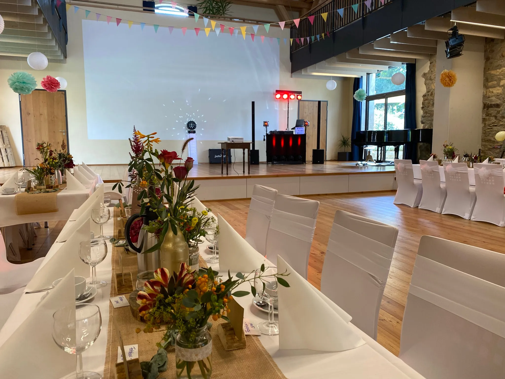 Hochzeitsdekoration in der Eventscheune mit blick auf die Bühne