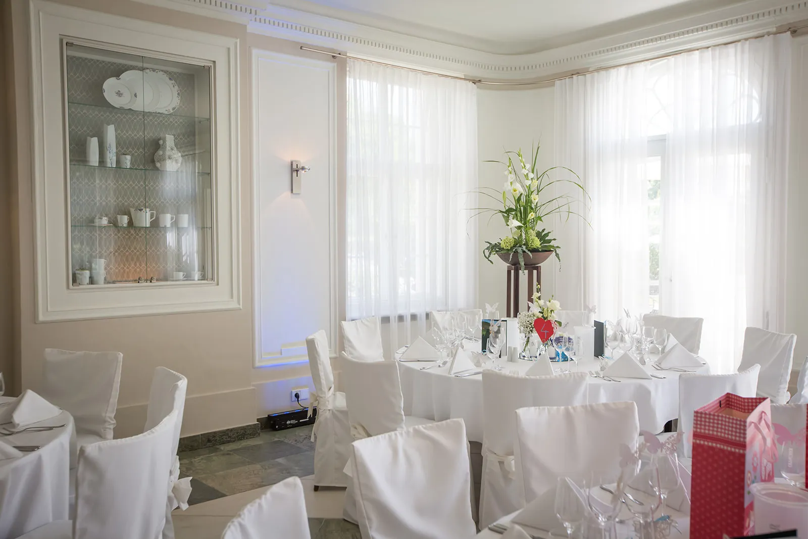 Kaminzimmer im Obergeschoss mit festlich eingedeckten Tischen und Blumengesteck
