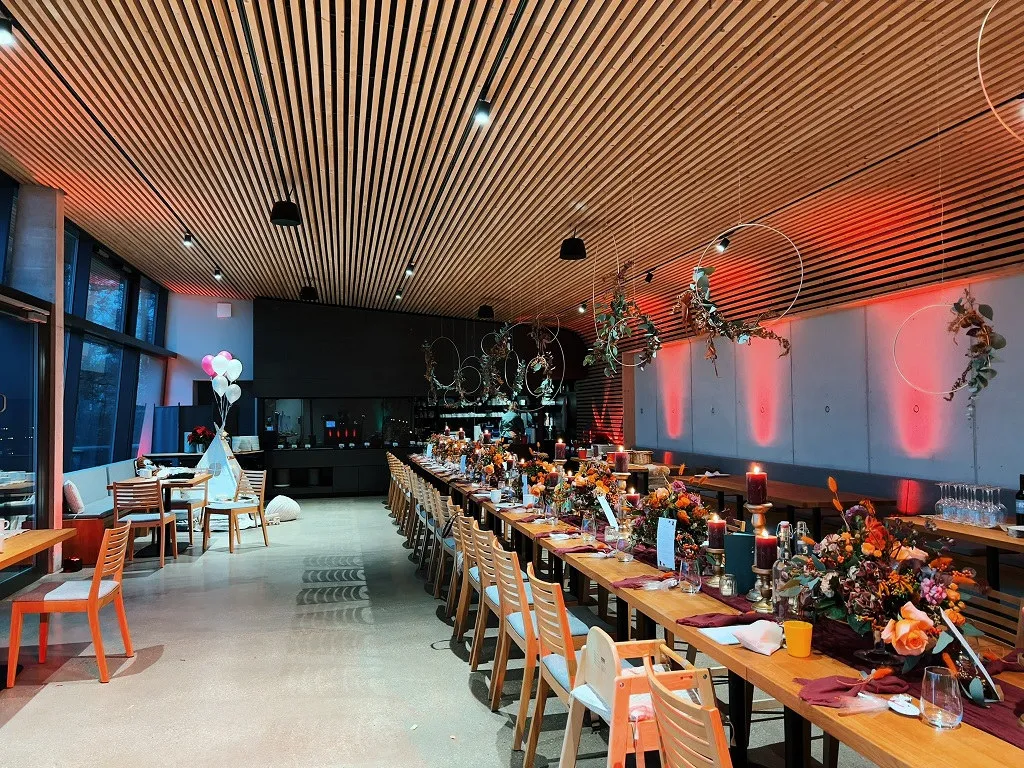 Langtafel im modernen Festsaal am Bieleboh mit Herbstblumen