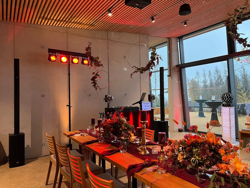 Lichtstativ mit roten Strahlern neben der eingedeckten Tafel