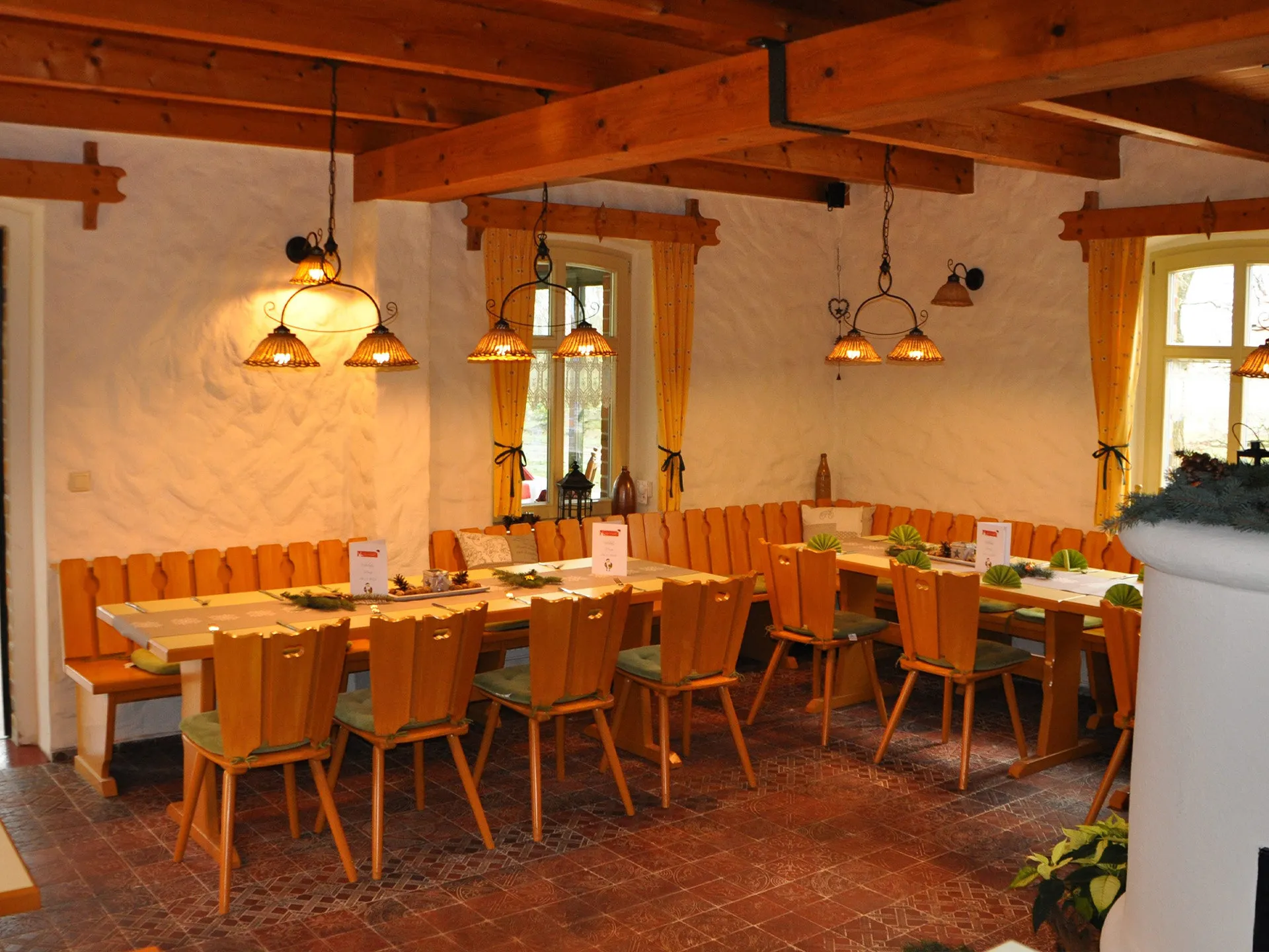 Rustikale Gaststube mit Holzbalken und langer Tafel