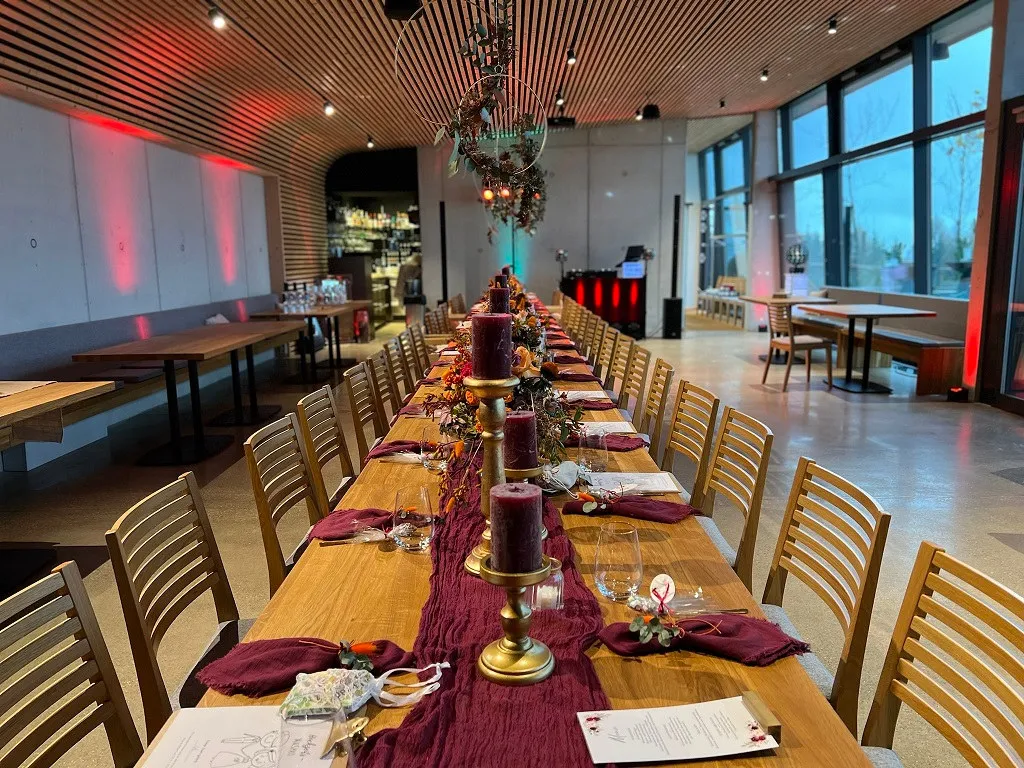 Tafel mit Goldleuchtern, bordeauxrotem Läufer und Menükarten