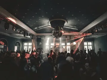 Tanzende Gäste unter einer Discokugel im festlichen Saal