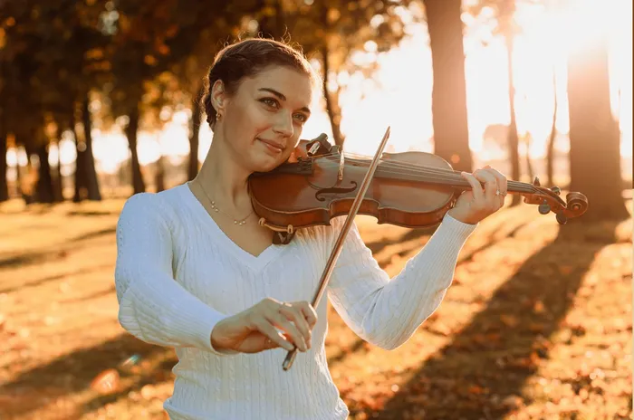 Violinistin Astrid Haferland spielt Geige im herbstlichen Park